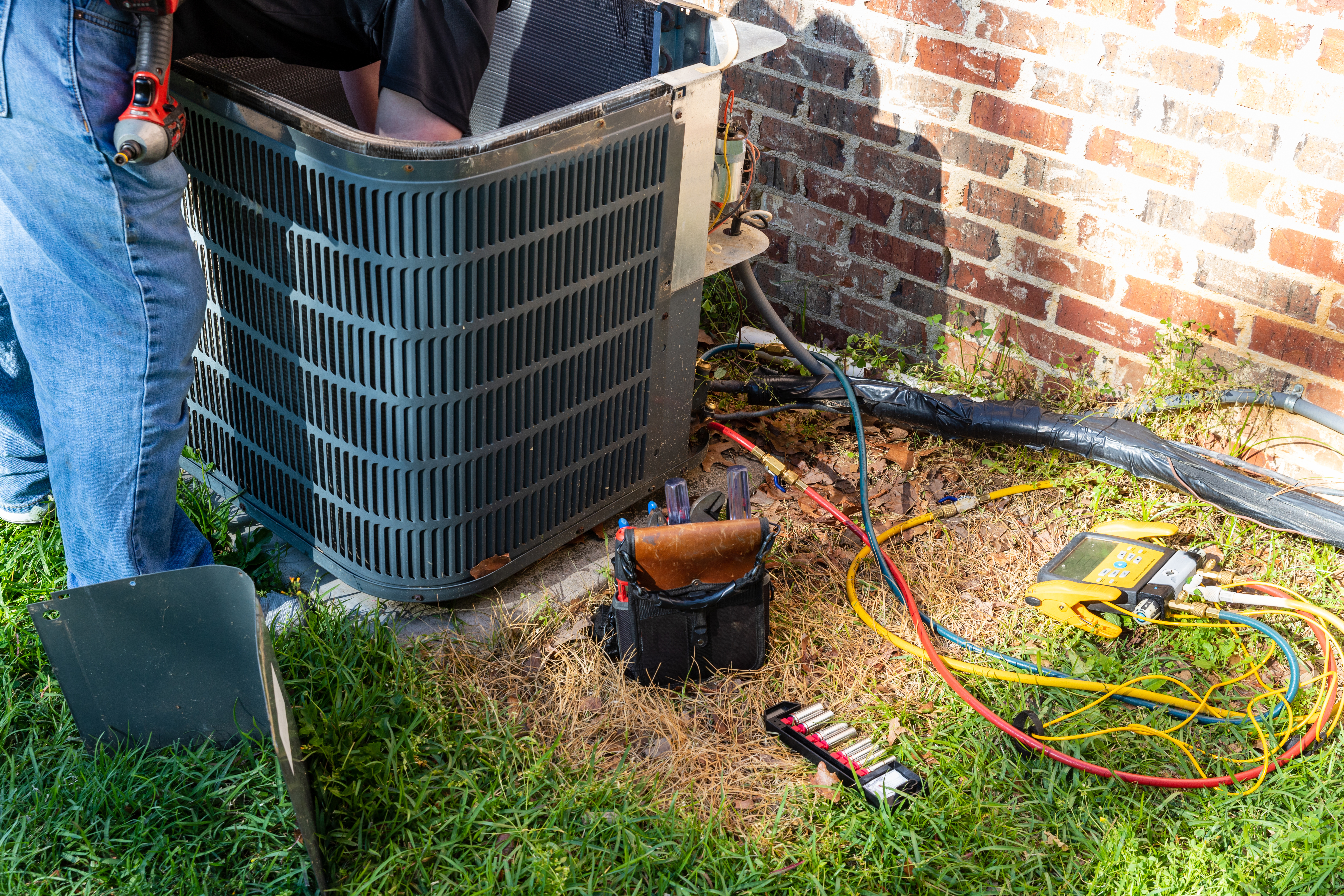 HVAC technician servicing AC unit — maintenance tune-up